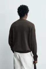 Sweater de punto regular fit fabricado en lana, color gris oscuro, con cuello redondo y manga larga. Cuenta con puños y cintura acanalados.