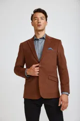 Blazer de pana color marrón, con cierre frontal de dos botones, solapas clásicas y bolsillos laterales con solapa.