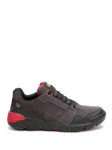 Championes Caterpillar modelo Gauge Pavement, de diseño robusto con capellada en gamuza gris y refuerzos en cuero sintético negro. Presenta detalles en color rojo en la suela y el talón, con cierre de cordones y logo de la marca en la lengüeta y el lateral.