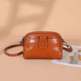 Cartera bandolera color tostado de diseño estructurado, con doble compartimiento con cierre, bolsillo frontal con solapa y tira ajustable desmontable.