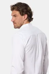 Camisa de lino color beige con cuello mao, manga larga, cierre frontal de botones y bordado sutil en el pecho.