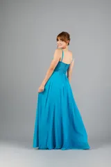 Vestido largo de fiesta color turquesa, con cuerpo tipo corset bordado con lentejuelas y transparencias, tirantes finos y falda fluida con tajo lateral.