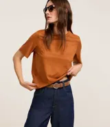 Blusa de manga corta y cuello redondo, confeccionada en tejido sintético de gamuza en color tostado.