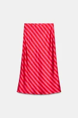 Falda midi fluida confeccionada en tejido satinado con estampado de rayas diagonales en tonos rojo y rosado, y cintura elástica.