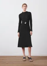Vestido midi negro de manga larga, con cuello alto drapeado y corte estructurado en la cintura, falda acampanada de caída suave.