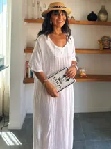 Vestido largo blanco de manga corta, con escote en V y detalles de bordado en el pecho y a lo largo del frente. El tejido es ligero y con caída.