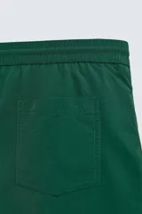 Bañador de hombre color azul marino, confeccionado en tejido técnico, con cintura elástica ajustable mediante cordón. Presenta bolsillos laterales y un bolsillo trasero de plastrón. Incluye forro interior.