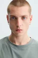 Camiseta gris de corte cuadrado y holgado, con cuello redondo y mangas cortas.