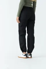 Pantalón cargo color beige de tiro medio, con bolsillos laterales tipo cargo y puños ajustables en los tobillos.