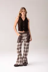 Pantalón de corte acampanado con diseño combinado. Presenta un estampado de cuadros tartán en tonos marrones, blancos y amarillos, con paneles laterales y bolsillos delanteros en cuero marrón oscuro.