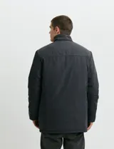 Campera de estilo Harrington en color verde oscuro, con cuello alto, cierre frontal y solapa con botones.