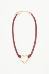 Collar de doble cordón trenzado color bordó con dije central en forma de corazón dorado. Cuenta con cierre de mosquetón y cadena de extensión metálica.