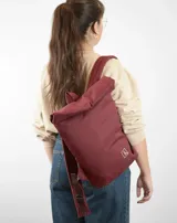 Mochila amarilla de tela con tiras de cuero color beige.