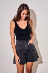 Bermuda de jean estilo wide leg, color negro lavado, con tiro medio, bolsillos laterales y ruedo desflecado.