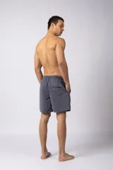 Short de baño de corte relajado en color gris azulado con efecto lavado. Cuenta con cintura elastizada con cordón ajustable, bolsillos laterales y una pequeña etiqueta decorativa en el ruedo.