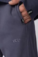 Pantalón de jogging de corte recto y fit relajado, confeccionado en tejido de algodón de color gris azulado. Presenta una caída amplia, cintura elástica y un pequeño logo bordado en la parte superior del muslo.