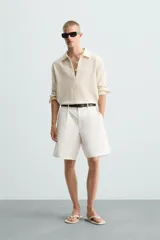 Bermuda de corte regular fit, color blanco hueso, confeccionada en tejido de algodón y lino. Presenta pliegues frontales, bolsillos delanteros y bolsillos traseros de plastrón.