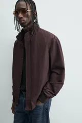 Cazadora azul marino de corte regular fit, confeccionada en tejido técnico repelente al agua. Presenta cuello subido, manga larga, bolsillos de vivo en cadera, bolsillo interior y acabados en rib en puños y bajo. Cierre frontal de cremallera oculta por solapa con botones a presión.