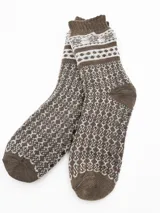 Medias de tejido grueso, color marrón y blanco, con diseño jacquard de patrones geométricos. Cuentan con puntos antideslizantes en la planta.