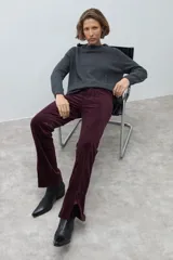 Pantalón de pana de corte recto y tiro medio, color ciruela, con detalle de tajo en el ruedo.