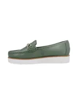 Mocasín de cuero color verde esmeralda con suela dentada blanca y detalle de hebilla metálica en el empeine.