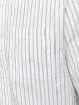 Camisa de vestir de manga larga a rayas verticales finas en tonos celeste y marrón sobre fondo blanco. Tiene cuello abotonado, bolsillo en el pecho y corte slim fit.