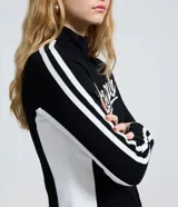 Campera deportiva de fleece color negro con cuello alto y cierre frontal. Presenta el lettering 'Oregon' bordado en el pecho y rayas blancas contrastantes a lo largo de las mangas.