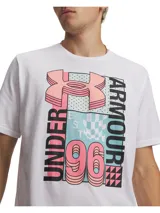 Remera de manga corta Under Armour con cuello redondo acanalado. Presenta un estampado gráfico frontal con el logo de la marca y tipografía retro en tonos rosado, celeste y negro sobre fondo blanco.