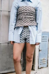 Short de tiro alto con estampado de lunares marrones sobre fondo celeste.