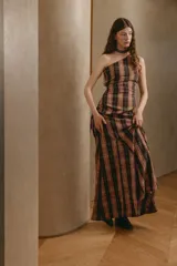 Top de un solo hombro con diseño asimétrico, confeccionado en tela con estampado de cuadros escoceses. Presenta jaretas laterales y en el dobladillo que crean un efecto drapeado y moderno.