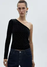 Top negro de terciopelo con escote asimétrico de un hombro y manga larga. Apliques de strass en todo el top.
