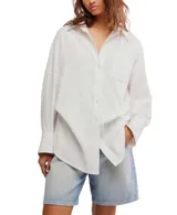 Camisa blanca de algodón con cuello clásico, manga larga y cierre frontal con botones. Tiene un bolsillo en el pecho y corte ligeramente entallado.