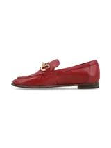 Mocasines de cuero rojo con herraje metálico dorado en el empeine, suela plana y costuras visibles.
