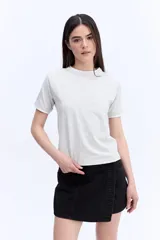 Remera de manga corta color gris melange, de calce regular y líneas simples, con detalles en contraste en el cuello y los puños.