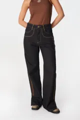 Jean de tiro alto y pierna recta, confeccionado en denim color azul oscuro. Presenta una franja lateral en tono marrón, costuras en contraste y tajos en el ruedo. Cuenta con diseño de cinco bolsillos y cierre frontal.