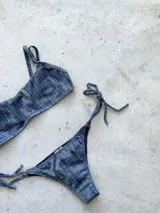 Conjunto de bikini color turquesa con tejido acanalado. El corpiño es tipo bandó con breteles finos regulables y espalda ajustable. La bombacha es vedetina con tiras ajustables a los costados.