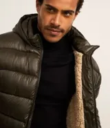 Campera puffer verde militar para hombre, con capucha, cierre frontal, bolsillos con cremallera y forro de sherpa.