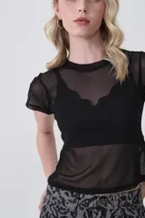 Remera de manga corta, cuello redondo y corte ajustado al cuerpo, confeccionada en tejido de poliéster con estampado de camuflaje en tonos verde militar, beige y marrón.