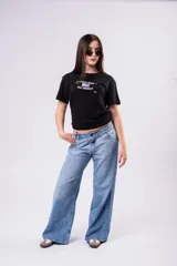 Pantalón de jean tiro bajo con corte wide leg y lavado celeste vintage. Presenta un diseño de pernera ancha y recta, con cierre de botón y cremallera, y bolsillos laterales y traseros.