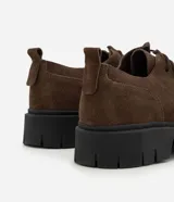Zapato masculino de cuero con textura gamuza, diseño moc toe y suela track robusta. Cuenta con cordones cortos y tirador trasero reforzado.