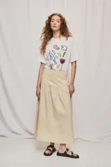 Falda midi de denim color beige, con diseño de volados y caída fluida.