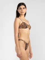 Bikini de dos piezas con estampado animal print en tonos rosado y naranja. El corpiño es de breteles finos y se ata en la espalda. La bombacha es de tiro bajo con cobertura mínima.