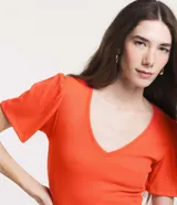 Blusa en viscosa acanalada color naranja, con escote en V, mangas cortas y detalle de pliegues en los hombros. Marca Marfinno.