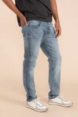 Pantalón de jean celeste, corte slim fit, tiro medio y bolsillos delanteros y traseros.