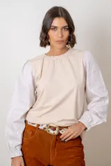 Remera de algodón con cuerpo en color beige y mangas largas abullonadas en color blanco. Presenta cuello redondo con frunce y puños elásticos.