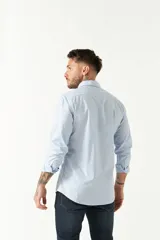 Camisa de manga larga para hombre, color azul claro con microestampado de cuadros. Presenta un corte slim y cuello abotonado.