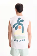 Musculosa blanca de algodón con estampado en la espalda que incluye una palmera, un sol, una isla y la frase "Sea La Vie".