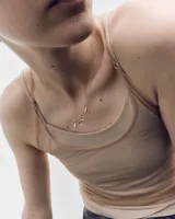 Charm Glow PDPAOLA de plata de ley con baño de oro de 18k, con un diseño orgánico e irregular que engasta una circonita transparente en el centro.