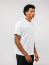 Remera de manga corta color blanco con cuello redondo. Presenta un pequeño logo circular de Umbro estampado en el pecho con la leyenda 'Born to Play'.
