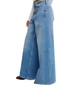 Jeans de mezclilla azul claro con corte palazzo extremadamente ancho y tiro alto. Presentan un efecto degradado o teñido que oscurece el color hacia los bajos de las piernas.